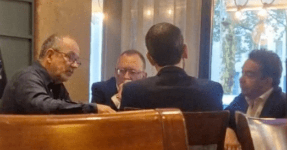 Photo prise dans un café parisien montrant une réunion discrète entre quatre hommes en pleine discussion. Cette scène est au cœur de l’affaire Legrand–Cohen, révélant des échanges entre journalistes et responsables politiques autour de la candidature de Rachida Dati à la mairie de Paris.